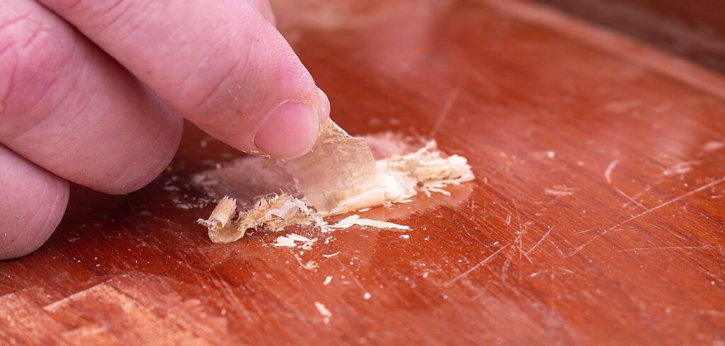 Detalhe da raspagem na madeira quando o acabamento é verniz: solta uma película